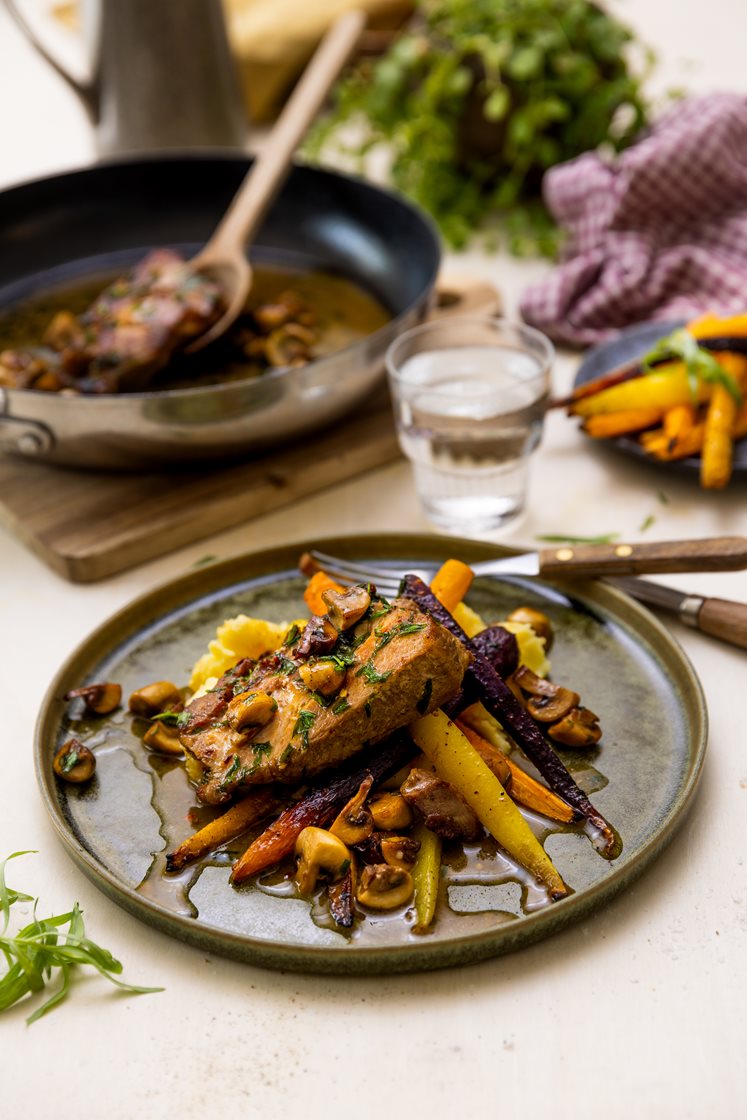 Mørkokt svinenakke med estragonsmør, hvitløksbakte regnbuegulrøtter og potetmos