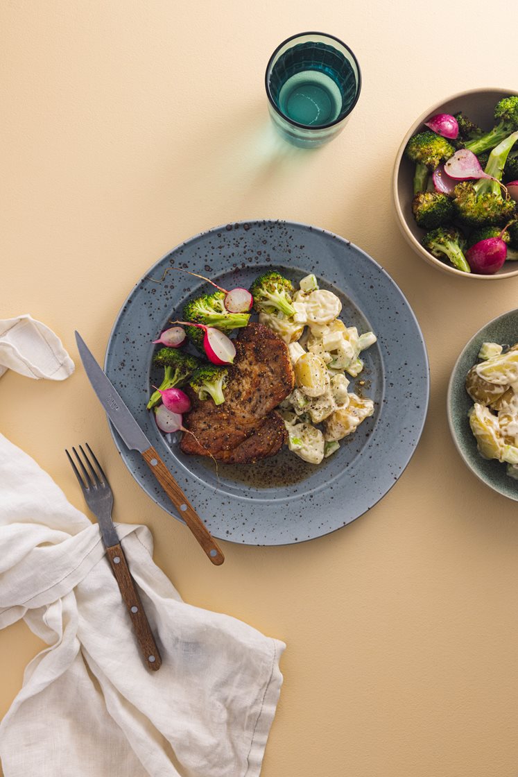 Sitrusstekt svinekam med ovnsbakt brokkoli og reddik, servert med potetsalat