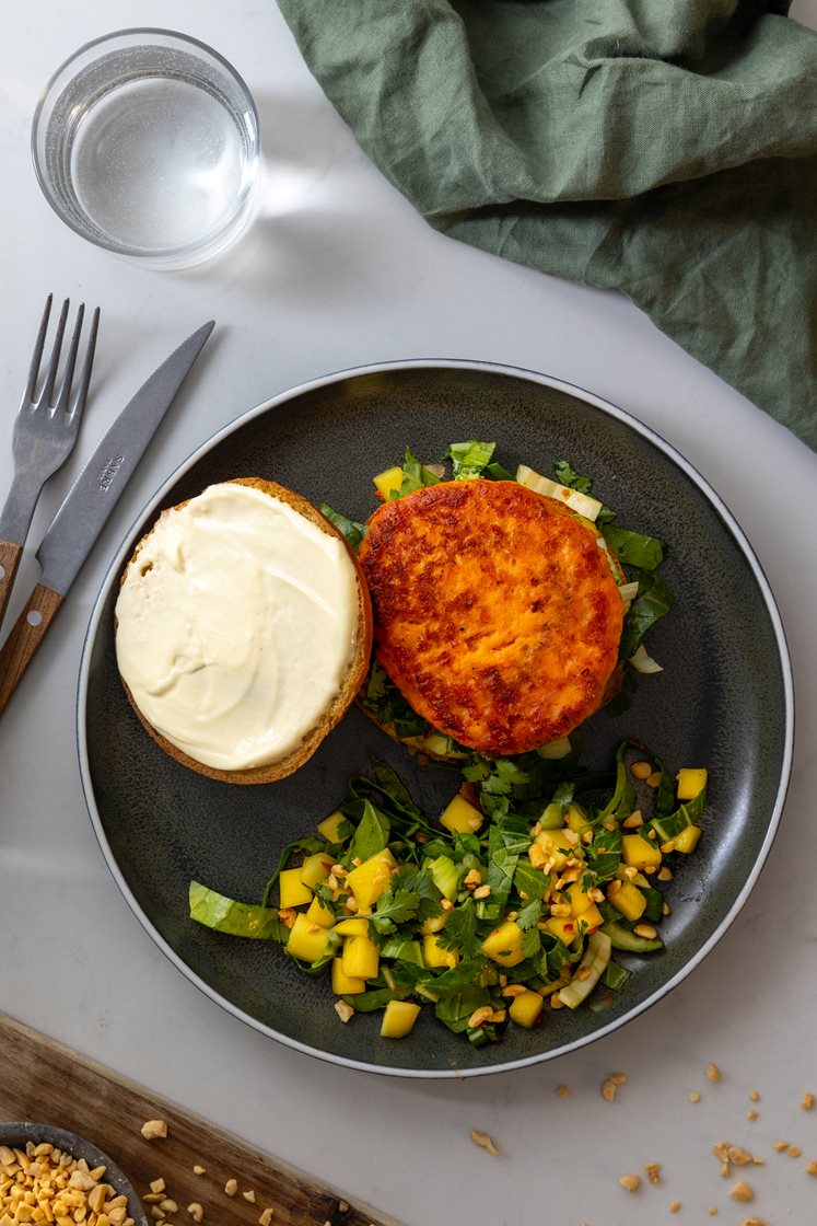 Ørretburger med med cheddar og chili, servert med marinert pak choysalat, mango og peanøtter