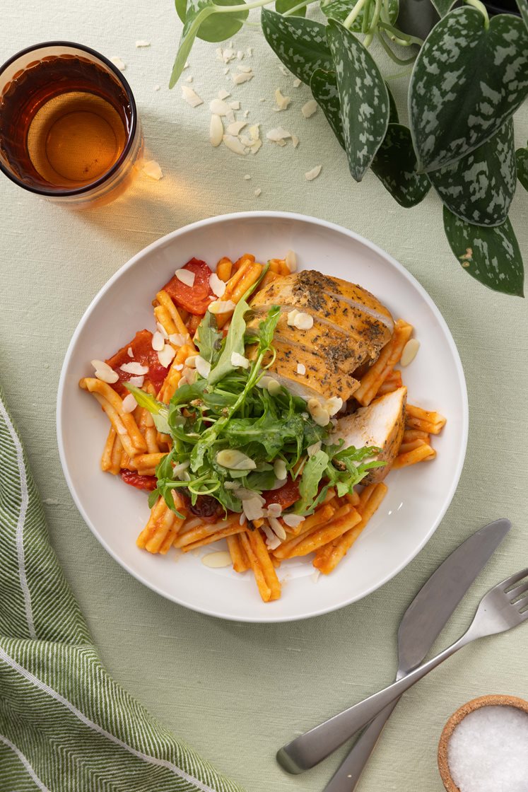 Pasta i romescosaus med kyllingebryst, rucola og mandler