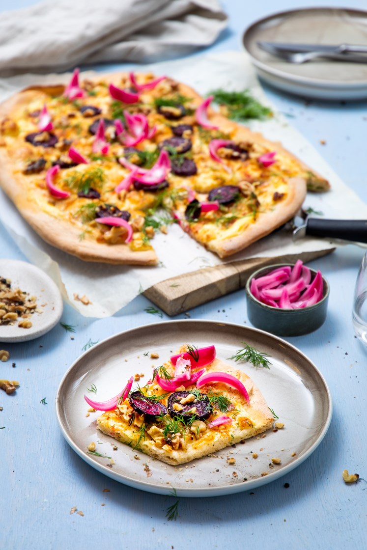 Hvit pizza med potet- og rødbeteskiver, pinjekjerner og lettsyltet rødløk