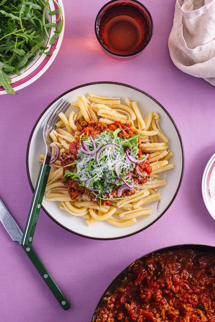Pasta bolognese laget med svin-, storfe- og linsedeig, toppet med ruccola og revet ost