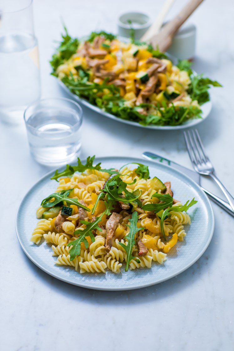 Kremet pasta med svinestrimler, paprika og squash servert med ruccola