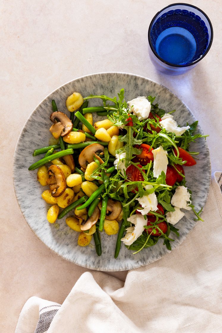 Pannestekt gnocchi med aromasopp og grønne bønner, servert med ruccola- og mozzarellasalat