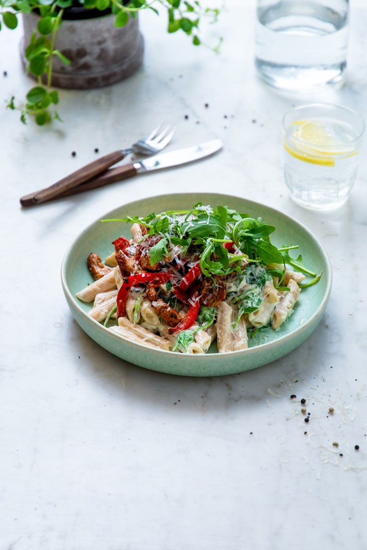 Marinerte svinestrimler med penne og spinat i crème fraîche-saus, toppet med ruccola og Grana Padano