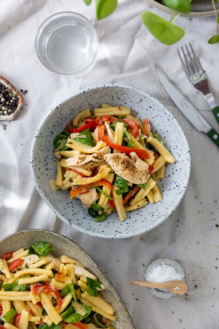 Skivet kyllingfilet og pasta casarecce i kremet paprikapesto, toppet med tomat