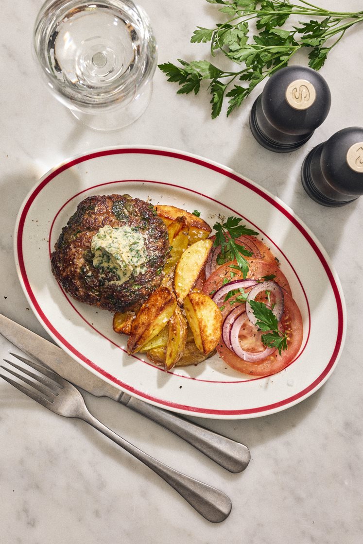 Steak haché med kapris, dijonsenap, persiljesmör och tomatsallad
